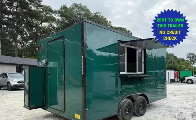 Green tandem-axle concession trailer with the service window and awning open and the rear door swung open, on the A&A Center Trailers lot