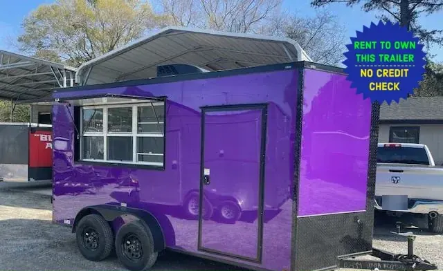 Purple tandem-axle concession trailer with a service window, side door and rooftop air conditioner, parked under a metal carport